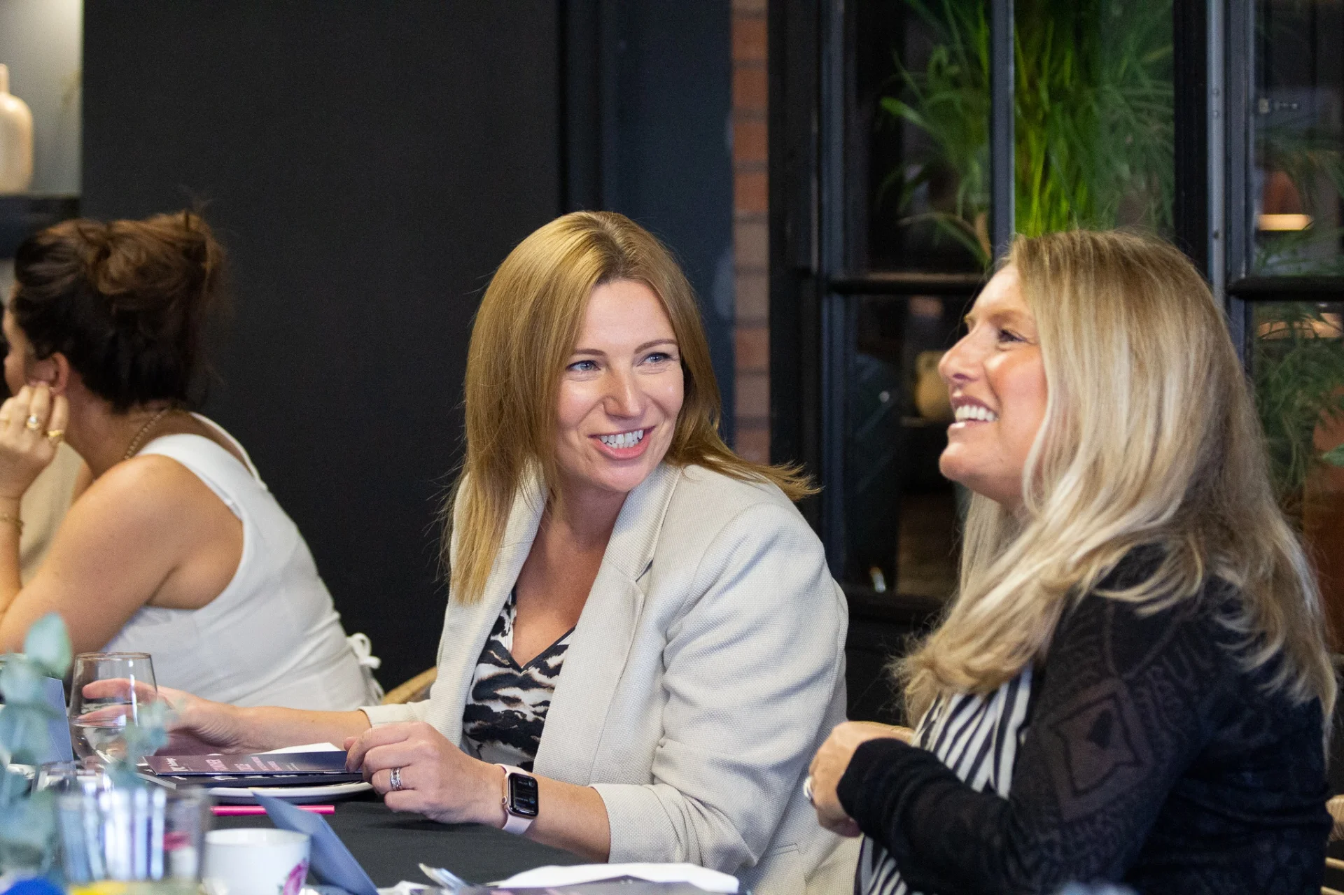 Two Strategic Circle members laughing together at a board day lunch