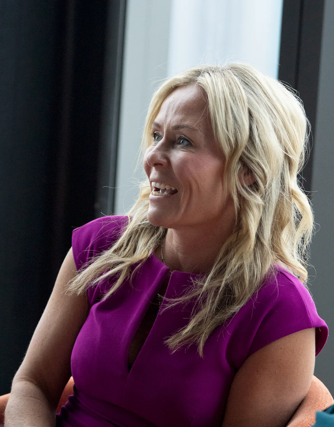 A Strategic Circle member in a magenta dress engaged in discussion during a board day