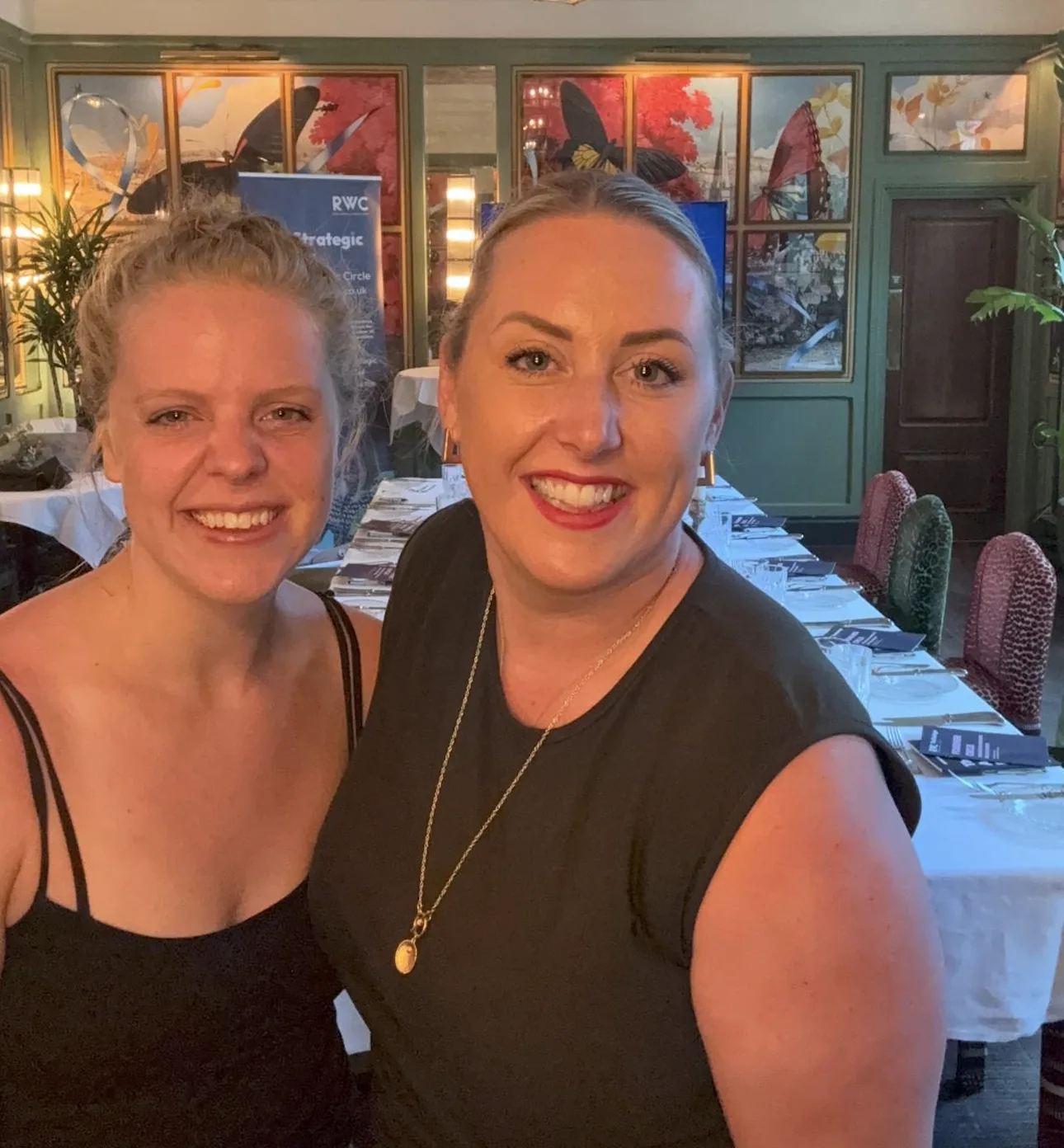 Two Strategic Circle members smiling together at an evening dinner