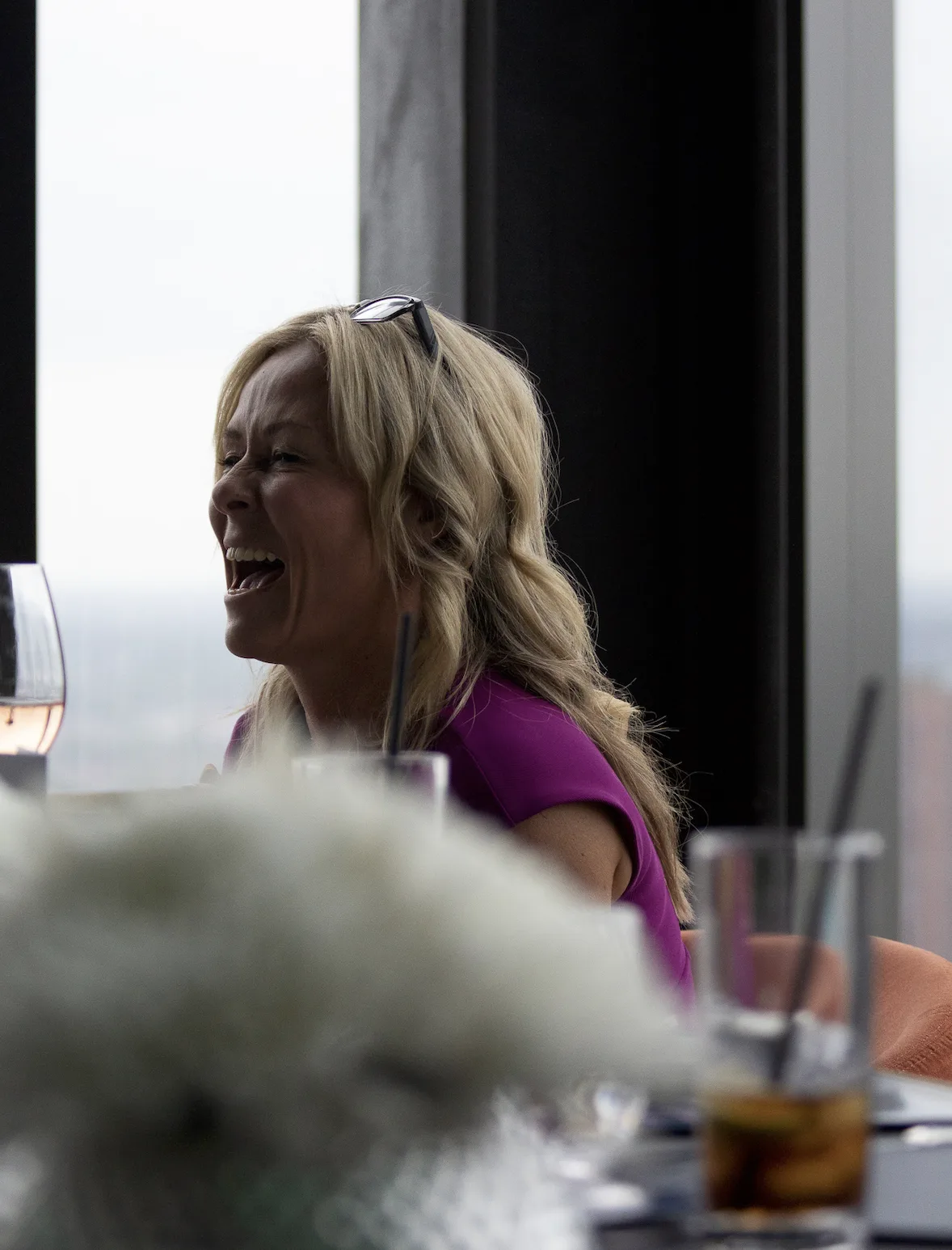 A Strategic Circle member laughing joyfully at a rooftop lunch with city views