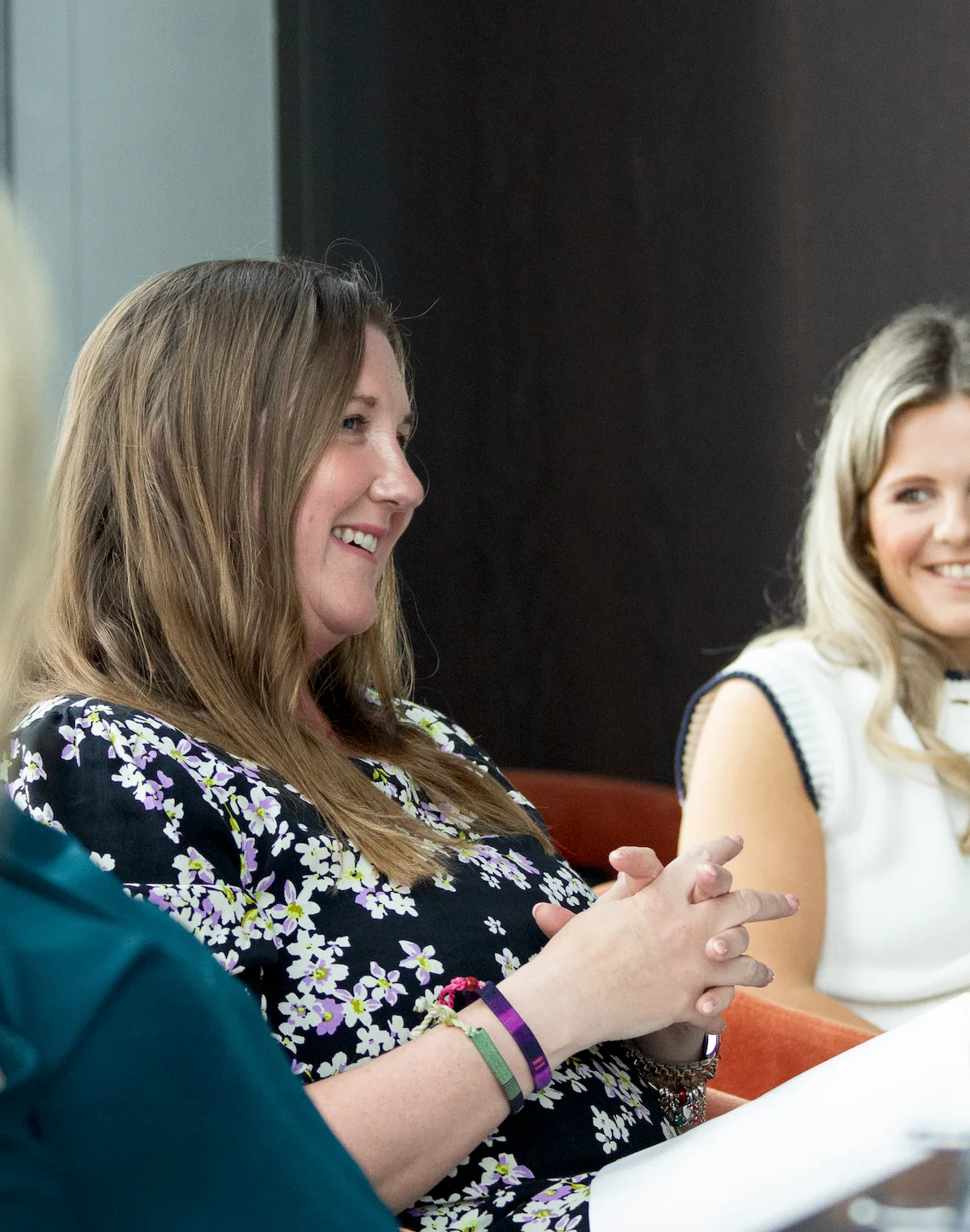 A Strategic Circle member listening and smiling during a boardroom conversation